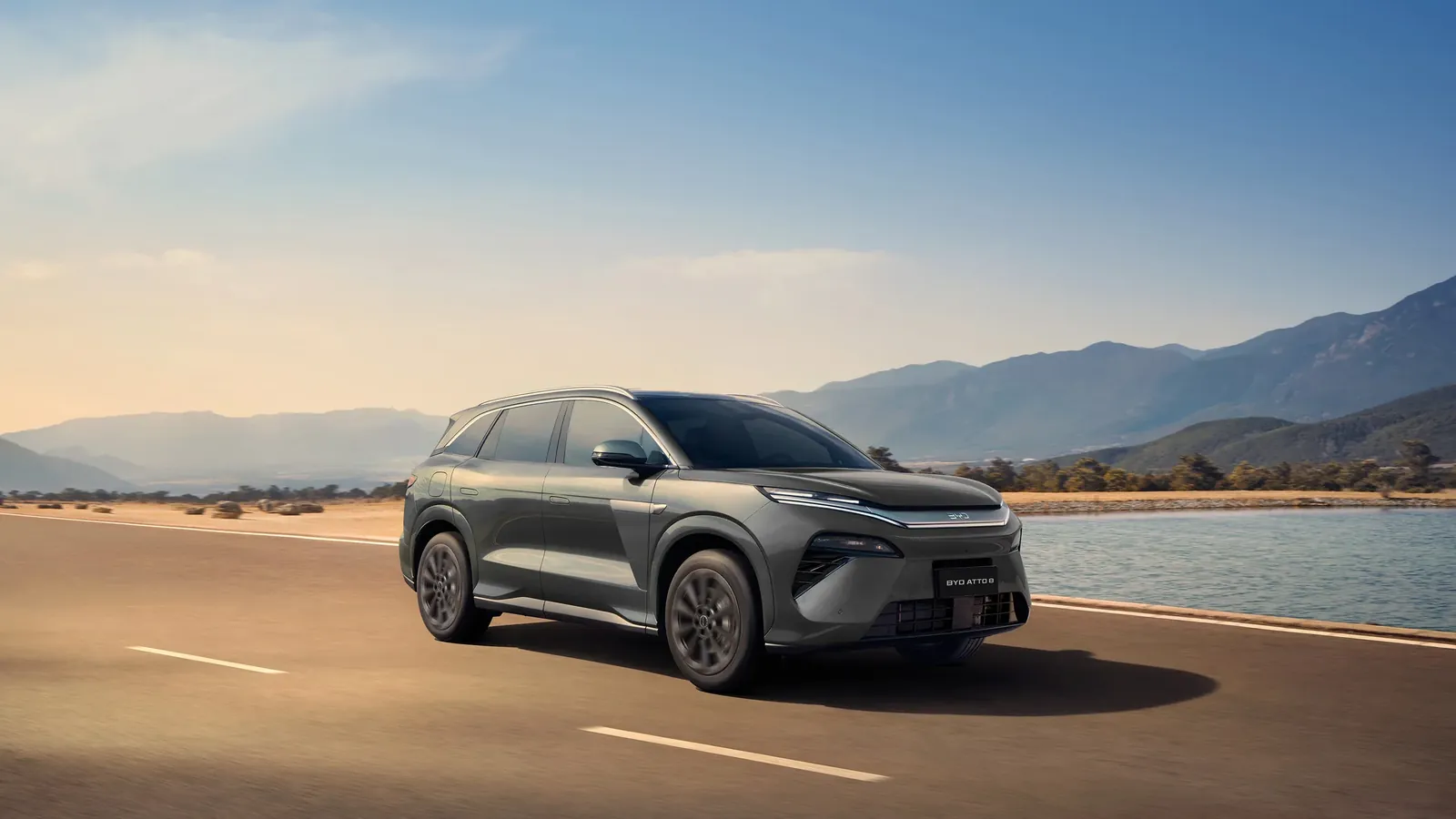 BYD Atto 8 cinza numa estrada à beira de um lago